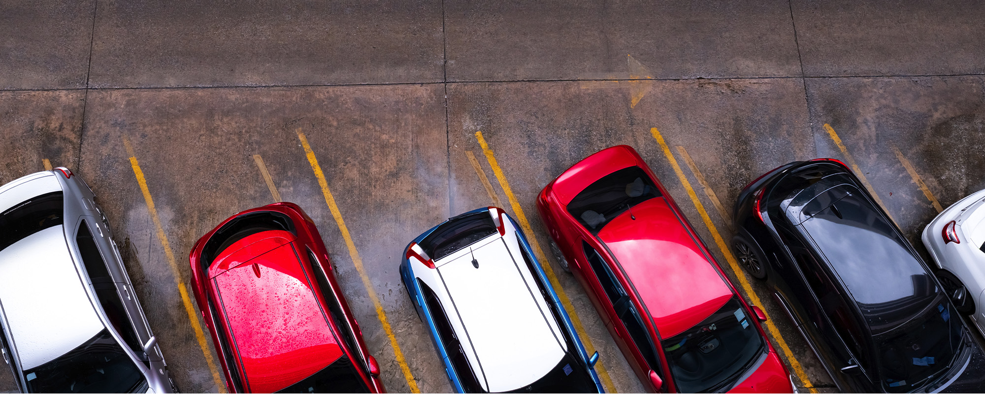 top view of car parked at concrete car parking lot with yellow line of traffic sign on the street. above view of car in 