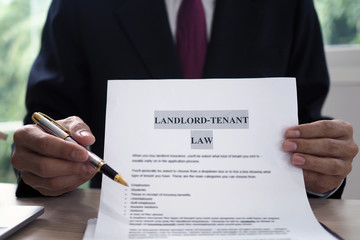 person holding paper that says landlord tenant law