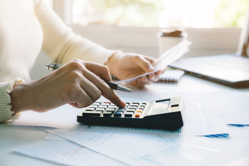 woman doing taxes on calculator