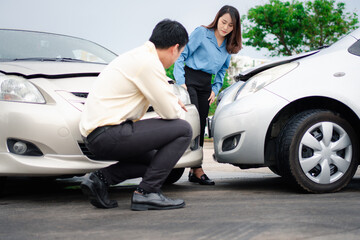 man and woman looking at car accident